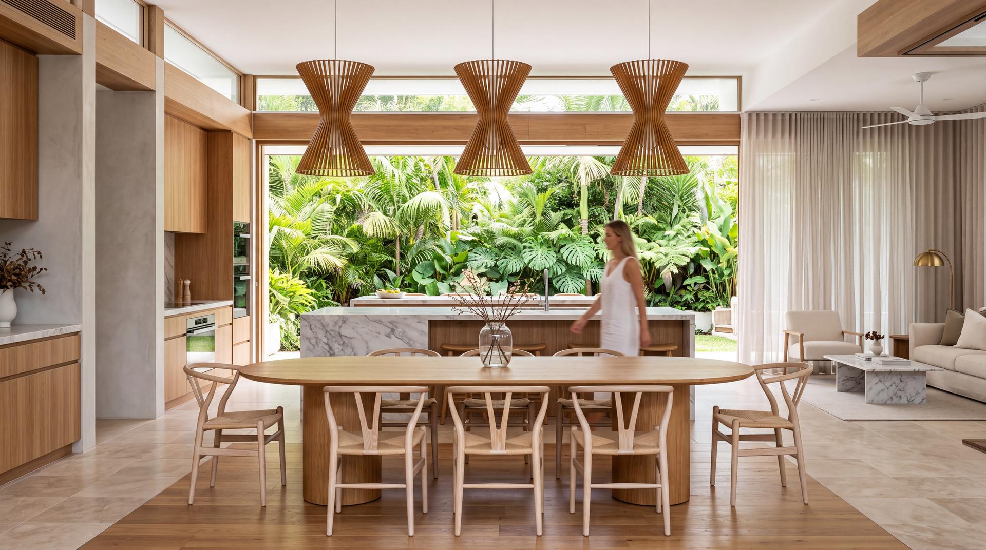 Kitchen and dining space opening onto a garden, with a figure at the island